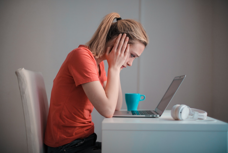 Woman looking at laptop screen trying to decipher her GMAT results.